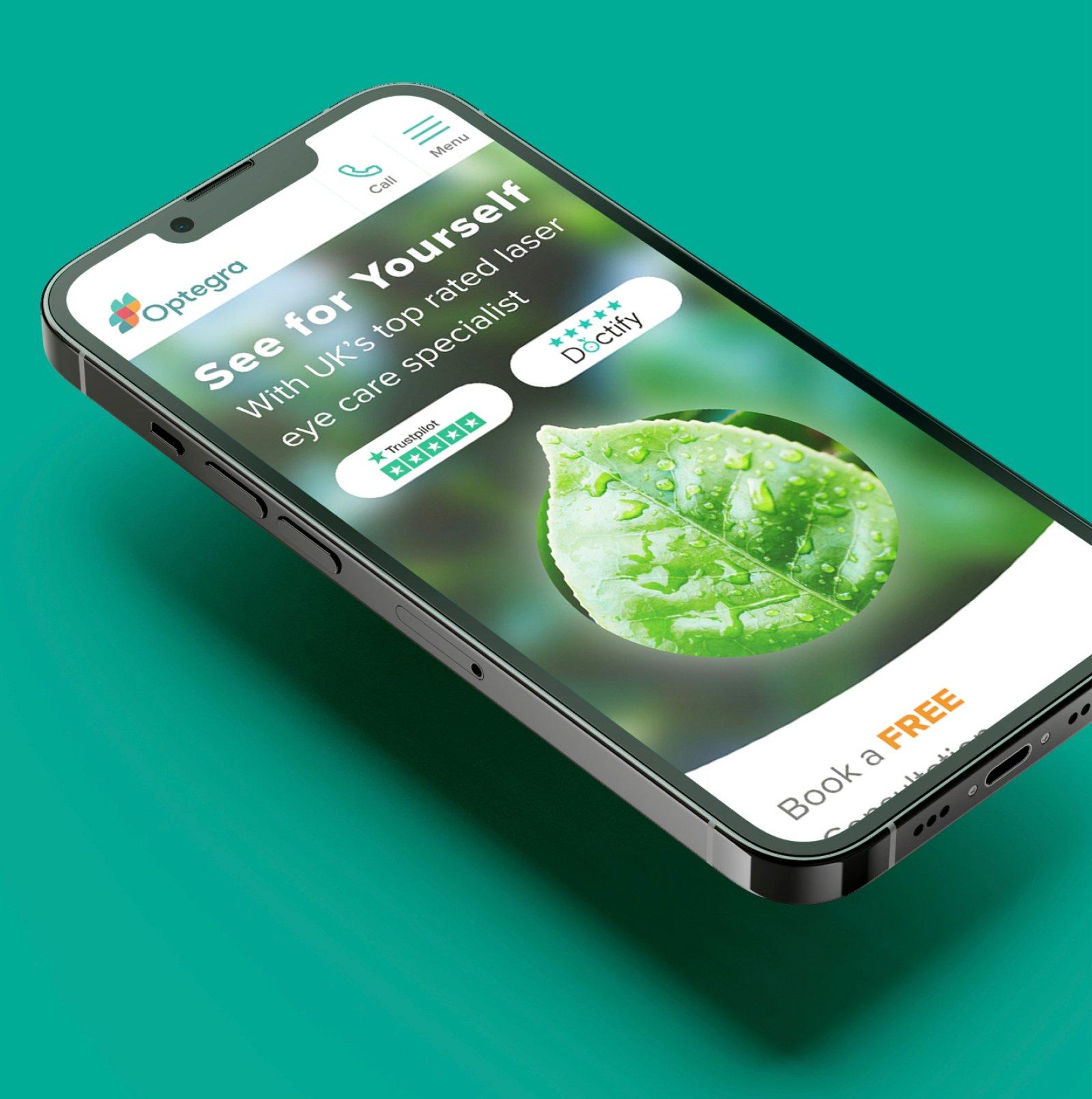 Optegra site on mobile, featuring a rich green background with a photo of a pinsharp leaf in the foreground