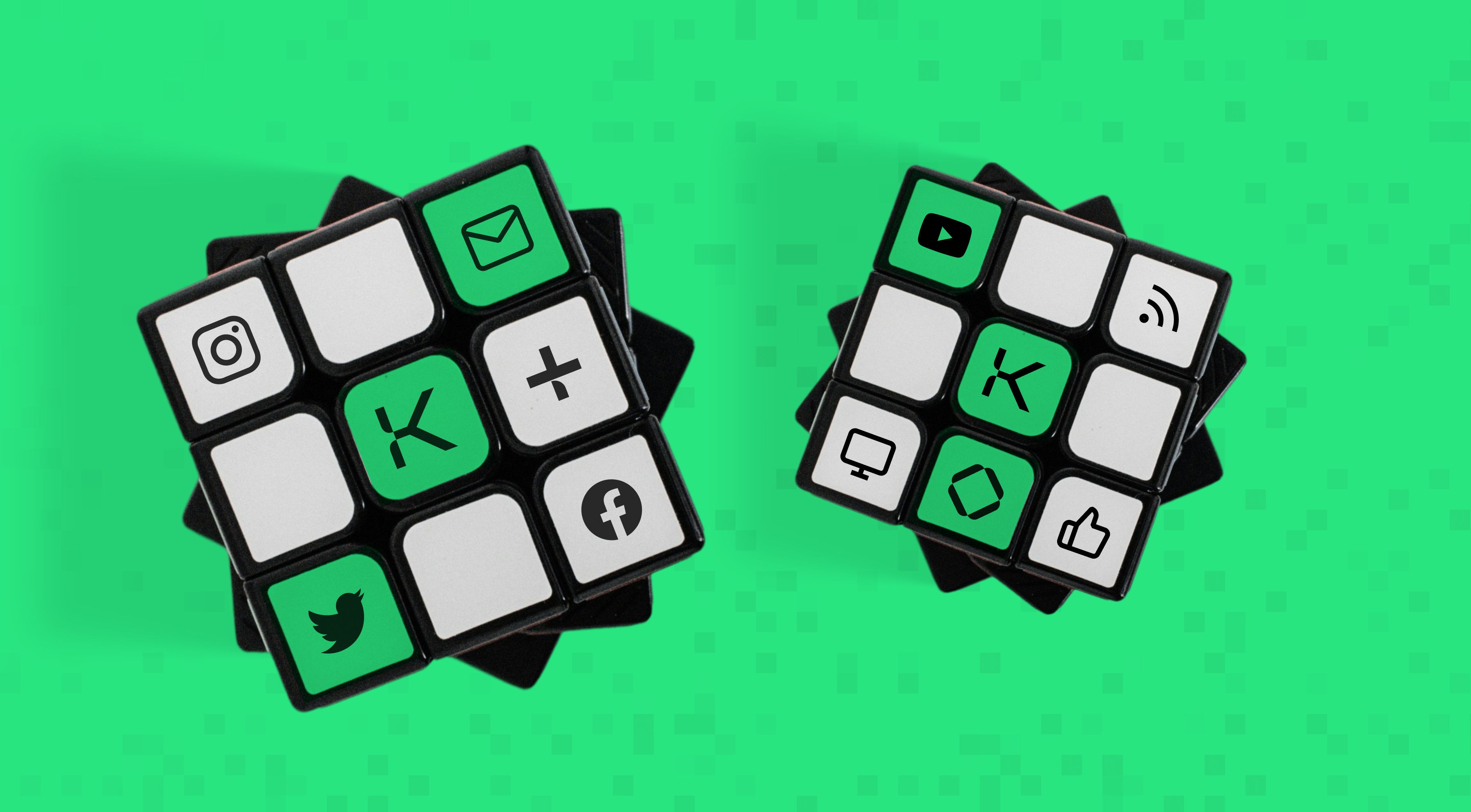 Two rubix cubes in white and black with green squares, showing social media logos