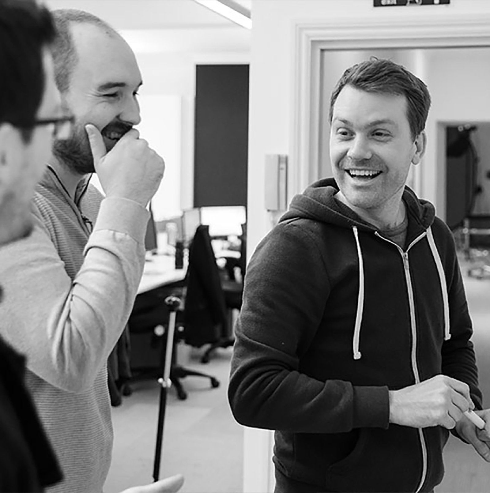 A photo of three of the Kalago team at a whiteboard