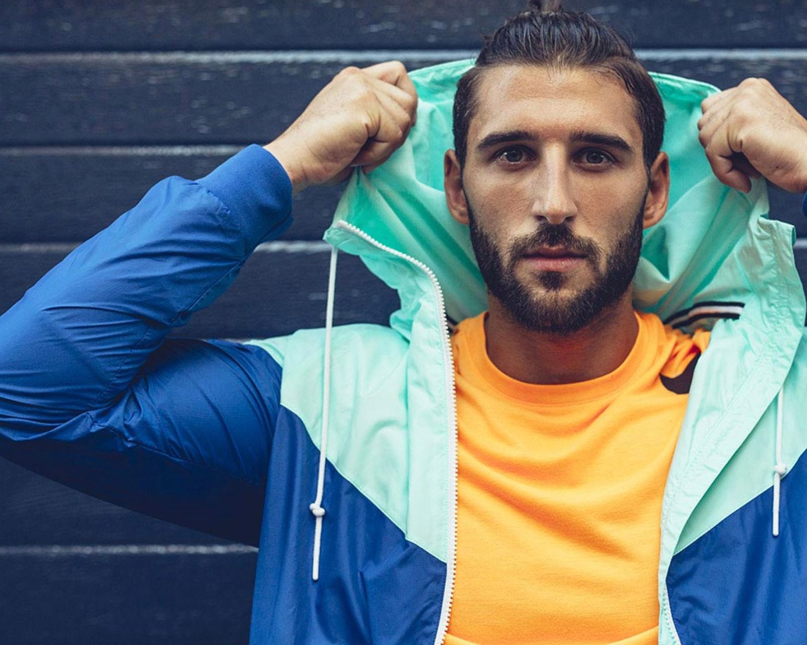 A photo of a young asian man with vibrantly coloured top